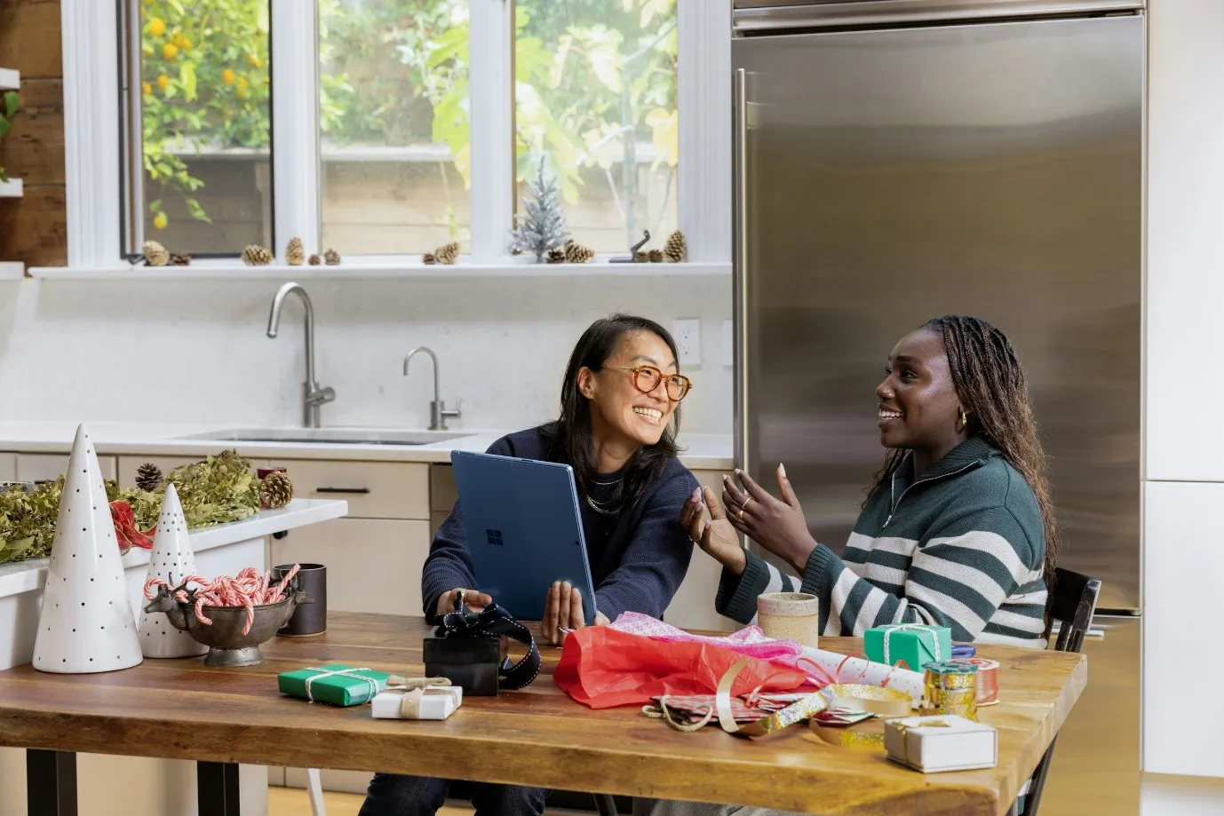 Two people working together at a kitchen table with a laptop